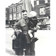 Max Stern in army uniform, Toronto, 1943. Ontario Jewish Archives, Blankenstein Family Heritage Centre, fonds 33, series 2, item 13.|This item is a photograph of Max Stern dressed in his army uniform, holding two children, Sheldon Glass and an unknown girl. They are standing in the street in front of Mandel's Creamery. Max Stern was stationed in Toronto.